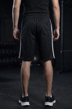 Man wearing black athletic shorts with white side stripes, rear view at the gym